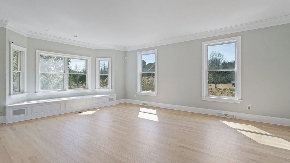 Empty living room with a bay window seat before virtual staging